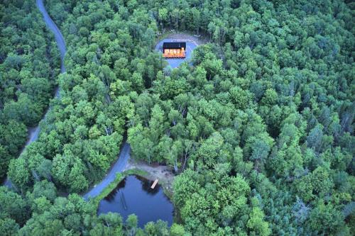 an aerial view of a house in the middle of a forest at KALLM-Mont-Tremblant chalet with hot tub, pond & beach on private 7acre estate in Lac-Superieur