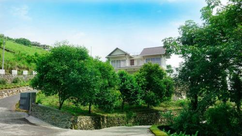 a house on the side of a hill with trees at Glashaus by Izan in Vagamon