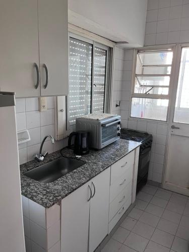 a kitchen with a sink and a microwave at Dpto Costanera in Corrientes