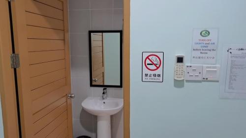 y baño con lavabo y espejo. en Salim Room, en Sibu