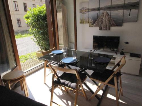 - une table à manger et des chaises dans une pièce avec fenêtre dans l'établissement Studio Cabine RDC pour 2/3 Pers avec Jardin, Parking, LL, LV, Wifi - Proche Thermes et Télécabine - FR-1-313-223, à Luchon
