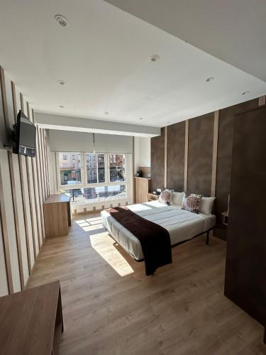 a bedroom with a bed and a large window at Calahorra Centro in Calahorra