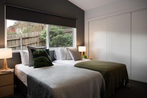 1 dormitorio con 2 camas y ventana grande en Delfryn, en Daylesford