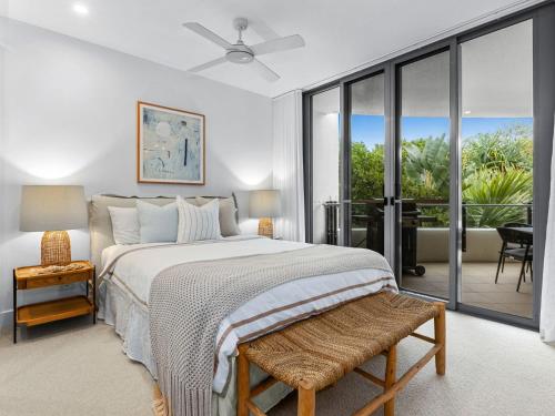 a bedroom with a large bed and a balcony at Cotton Beach 94 Mid-Floor Penthouse with Bush View in Casuarina