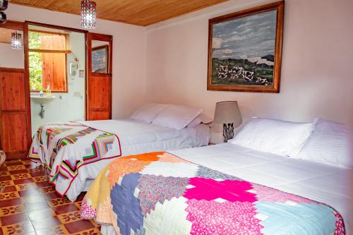 um quarto com duas camas e uma foto na parede em Hotel Kantarrana Urbana Jardin em Jardín