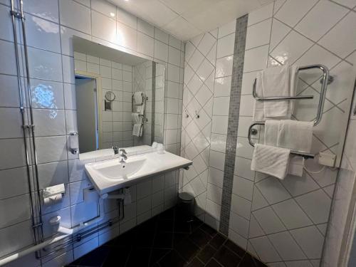 a white bathroom with a sink and a mirror at Hotell Siesta in Karlskrona