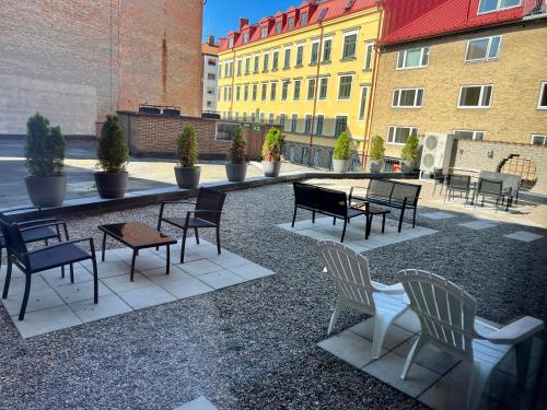 a group of chairs and tables in a courtyard with buildings at Hotell Siesta in Karlskrona