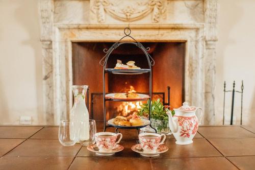 a table with a fireplace with a plate of food at Estancia La Paz Hotel in Ascochinga