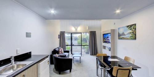 a kitchen and living room with a sink and a table at Arista of Rotorua in Rotorua