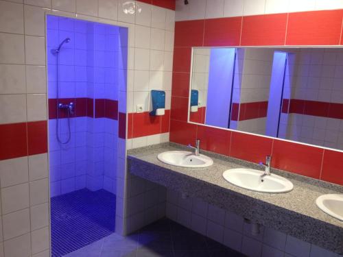 a bathroom with three sinks and three mirrors at Albergue @ Muxia in Muxia