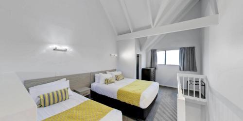 a hotel room with two beds and a window at Arista of Rotorua in Rotorua