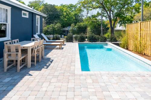 a patio with a table and chairs next to a swimming pool at 106 the Church St Collection with pool in Fairhope