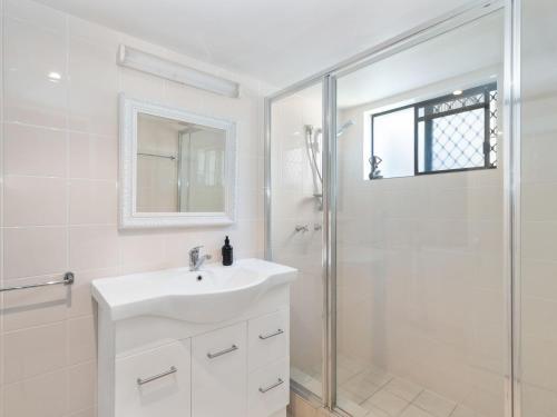 a white bathroom with a sink and a shower at Deja Blue on the Creek in Kingscliff