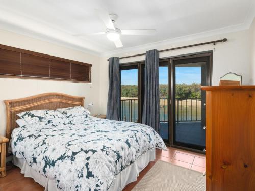 a bedroom with a bed and a balcony at Deja Blue on the Creek in Kingscliff