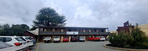 a parking lot with cars parked in front of a building at Shepparton Golf Motel in Shepparton
