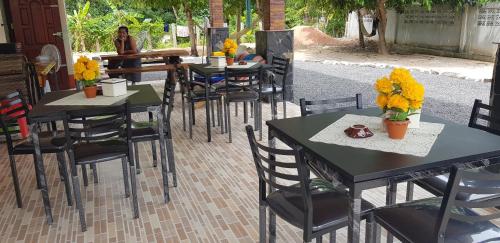 a group of tables and chairs with yellow flowers on them at Khwahol Guesthouse in Don Sak