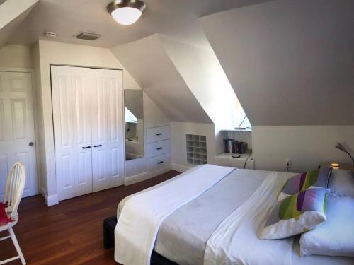 Un dormitorio con una gran cama blanca y una escalera en Cozy Chalet near the Design District, en Miami