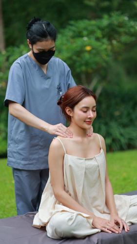 a man standing next to a woman sitting on a table at Hotel Labaris Khao Yai in Mu Si