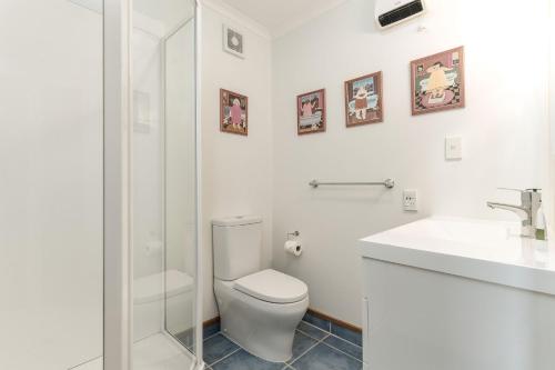 a white bathroom with a toilet and a sink at A Room With a View in Kaikoura