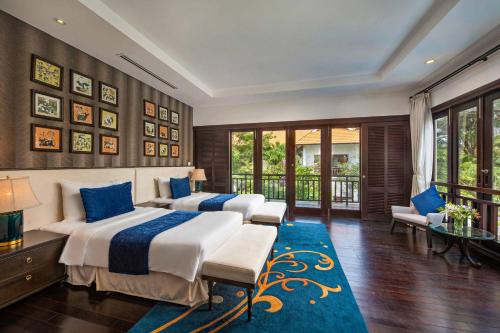 Luxury Danatrip Villas في دا نانغ: غرفة نوم بسريرين وسجادة زرقاء
