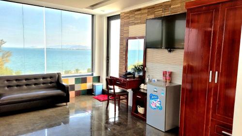 a living room with a couch and a large window at Ninh Chu Hotel in Phan Rang