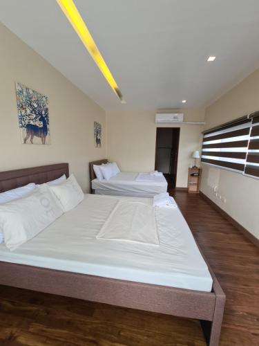 a bedroom with two beds and a window at Serenity Home near Ayala Malls Serin in Tagaytay