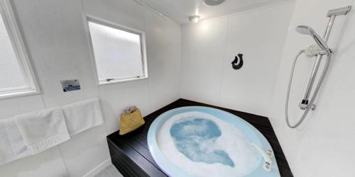 Das Bad ist mit einer Dusche und einer Badewanne ausgestattet. in der Unterkunft Capri on Fenton in Rotorua
