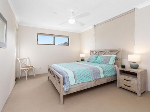 a bedroom with a bed and a table and a chair at Tradewinds 1 on Kingscliff Beach in Kingscliff