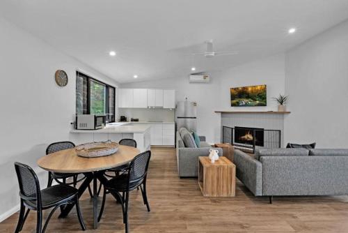 a kitchen and a living room with a table and a couch at Reflections Seal Rocks - Holiday Park in Smiths Lake