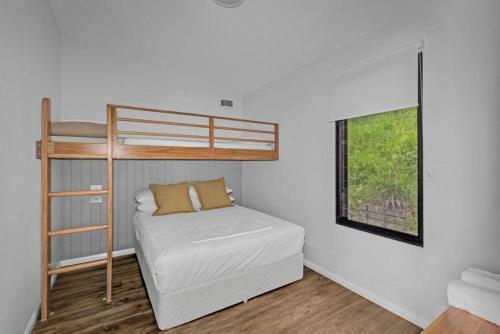 a small bedroom with a bunk bed and a window at Reflections Seal Rocks - Holiday Park in Smiths Lake