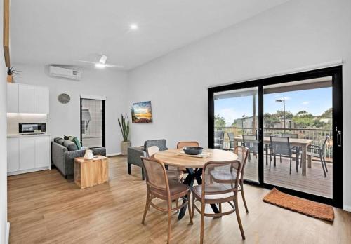 a kitchen and living room with a table and chairs at Reflections Seal Rocks - Holiday Park in Smiths Lake