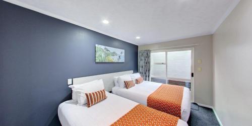 a bedroom with two beds and a window at Capri on Fenton in Rotorua