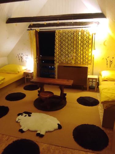 a living room with a table and a white cat on the floor at Chata Hvězdička in Litoměřice