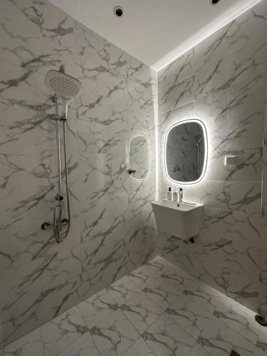 uma casa de banho branca com um lavatório e um espelho em استديو مودرن فاخر - دخول ذاتي em Riade