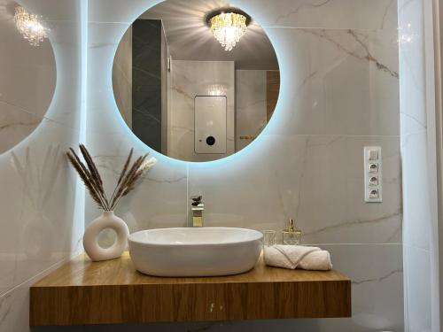a bathroom with a white sink and a mirror at Apartament Lux SunRise in Żywiec