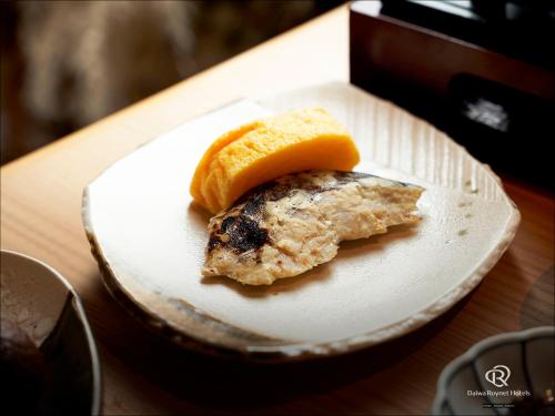 a piece of food on a plate on a table at Daiwa Roynet Hotel Yamagata Ekimae in Yamagata