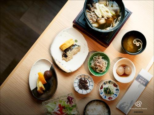 uma mesa coberta com pratos e uma caixa de alimentos em Daiwa Roynet Hotel Yamagata Ekimae em Yamagata