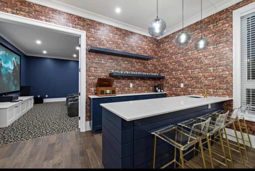 a kitchen with a brick wall and a blue counter at Big and Luxury House in Surrey