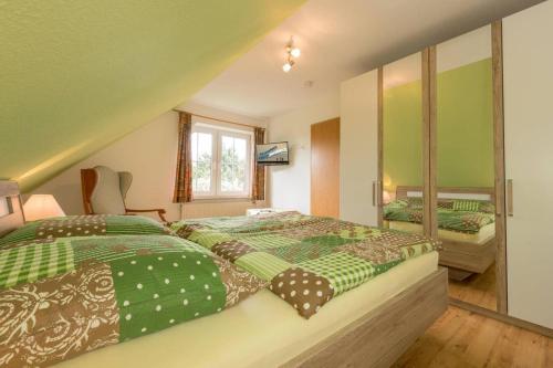 ノルトダイヒにあるFerienhaus Fritzのベッドルーム1室(緑と茶色のシーツが備わるベッド1台付)