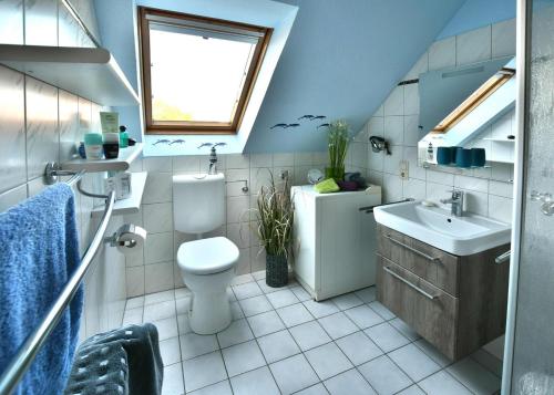 ノルトダイヒにあるFerienhaus Fritzのバスルーム(トイレ、洗面台付)、窓が備わります。