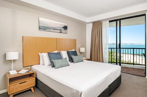 1 dormitorio con 1 cama grande y balcón en Mantra Coolangatta Beach, en Gold Coast