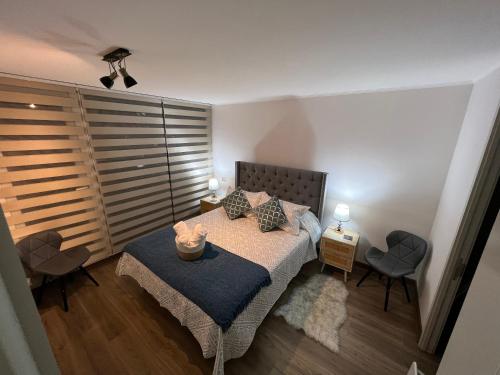 a bedroom with a bed with a table and two chairs at Galardon AyC in Concepción