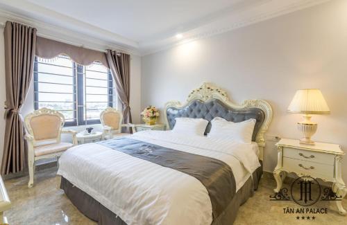a bedroom with a large bed and a chair at Tan An Palace in Hai Phong