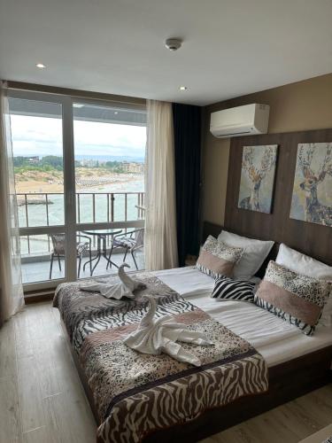 a bedroom with a large bed with a balcony at Sea View Private Studio Paradiso B 508 in Nesebar