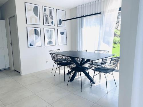 a dining room with a black table and chairs at Villa californienne à 10 minutes à pied du centre-ville in Vence