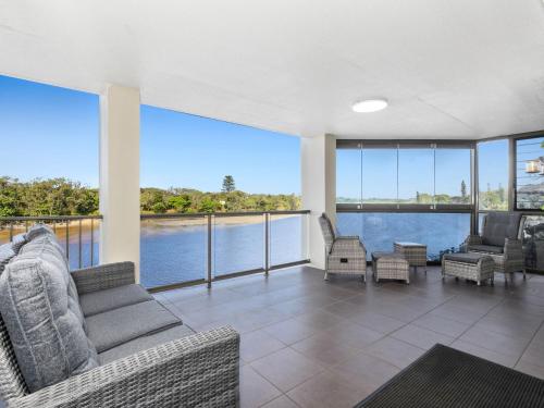 a large living room with a view of the water at Sunset Waters Creekfront Apartment in Kingscliff