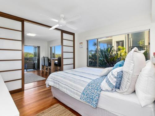a bedroom with a bed and a large window at Sunset Waters Creekfront Apartment in Kingscliff
