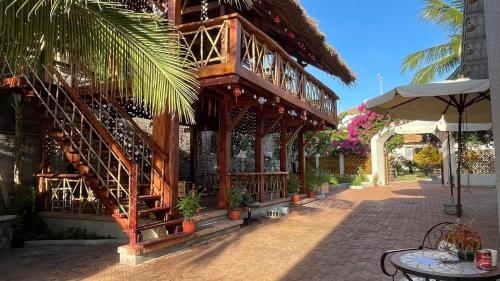 - un bâtiment en bois avec un balcon et une terrasse dans l'établissement GOLDEN LOTUS SPA & HOMESTAY, à Ấp Thiện Phước