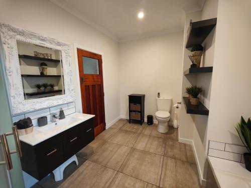 a bathroom with a sink and a toilet at Church Street Charmer in Riverton
