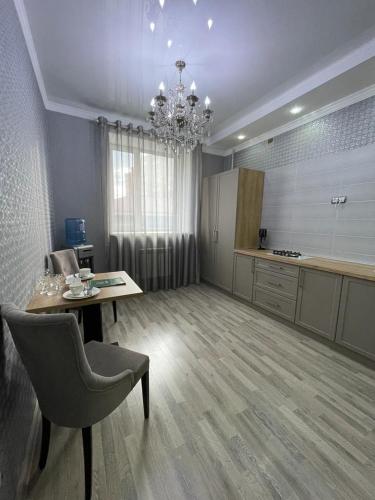 a large room with a table and a chandelier at Апартаменты в центре города ЖК Арман in Aktobe
